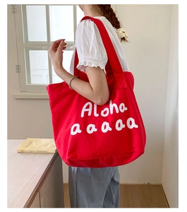 Close-up of a large red canvas tote bag with Aloha lettering for summer beach vacation