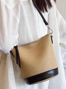 Sac seau en paille tressée beige et noir avec bandoulière cuir pour look estival chic