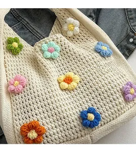 Detail of handmade crochet handbag with colorful floral patterns and hollow weave