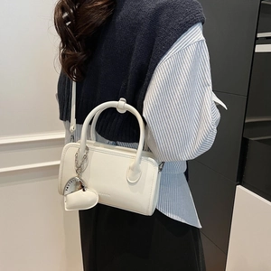 Detail shot of the white PU leather bowling bag showing the Clearok logo and heart pendant