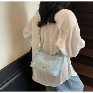 Detailaufnahme der hellblauen Denim Hobo Tasche mit silbernen Schmetterlingsdekor