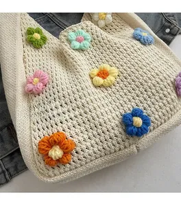 Close-up of handmade crochet tote bag featuring multi-color floral embroidery details