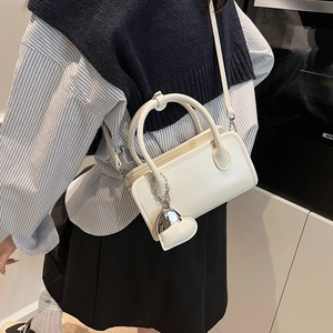 Detail of cream white PU leather bowling bag with silver heart charm and adjustable strap