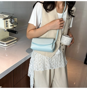 Détail de vue latérale d'un sac à bandoulière bleu clair texturé sur un mannequin