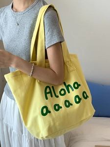 Yellow canvas tote bag with green Aloha print, ideal for large capacity summer travel