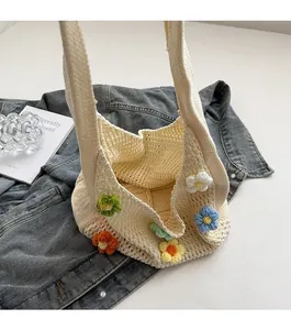 Detail of cream handmade crochet bag with magnetic clasp and colorful floral embroidery