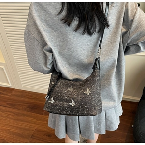 Detailaufnahme der glitzernden grauen Achseltasche mit silbernen Schmetterlingen