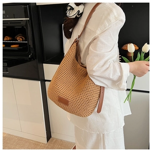 Detail of hand-woven texture on khaki cotton rope bucket bag with brown leather strap