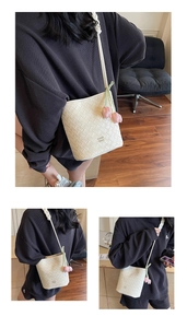 Detail of cream woven leather bucket bag with pink tulip charms and metal logo branding