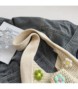 Detailed view of handmade crochet shoulder bag featuring colorful 3D flower appliques
