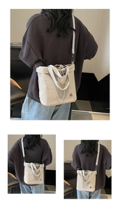 Detail of beige canvas bucket bag with drawstring closure and adjustable strap