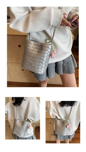 Detail of silver woven bucket bag with pink tulip charm and slim crossbody strap