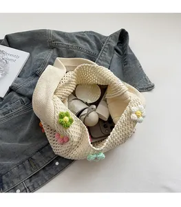 Detail of hand-woven tote bag with 3D crochet flowers showing large internal storage capacity
