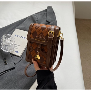 Detail view of mini crossbody bag with retro print and gold logo on grey blazer