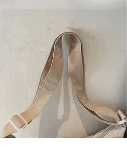 Dettaglio della borsa tote in nylon beige con tracolla regolabile e fibbia in resina