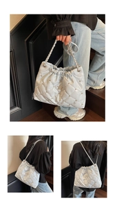 Detail view of light blue quilted cloud bag with star metal logo and silver rivets