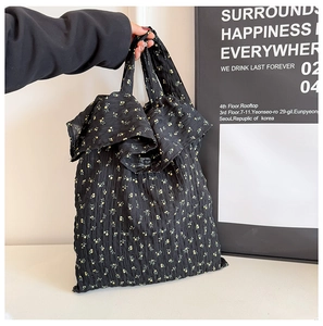 Détail du sac en toile floral montrant les plis noirs et les motifs de petites fleurs jaunes