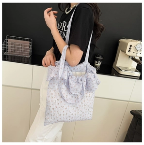 Détail d'un sac cabas en toile à fleurs avec des bords plissés et un style champêtre