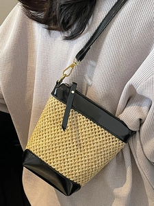 Fashionable straw crossbody bucket bag for summer 2025 with black leather trim detail
