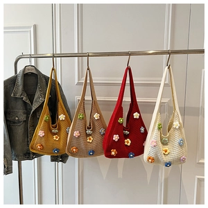 Detail of four handmade crochet shoulder bags with colorful floral knits in various colors