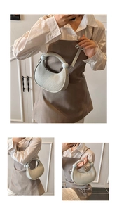 Detail of light grey crescent shoulder bag with vertical pleats and ring handle
