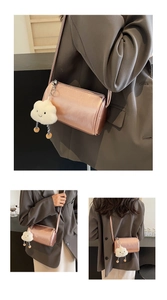 Details einer metallisch roségoldenen Zylindertasche mit flauschigem Wolkenanhänger