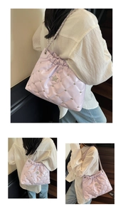 Detail of lavender quilted bucket bag with silver star and rivets on a chain strap