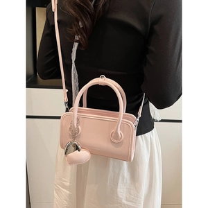 Pink PU leather bowling handbag with heart charm and adjustable shoulder strap