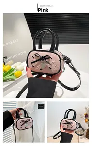 Détail du sac rose avec nœud, pendentif en cœur et surface en cuir synthétique texturé