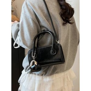 Glossy black PU leather bowling bag with twin handles and heart charm accessory