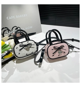 Détail de mini sacs à volants rose et crème avec nœuds noirs et breloques en cœur