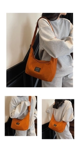 Dettaglio di una borsa a tracolla a mezzaluna arancione acceso con chiusura lampo e cinturino