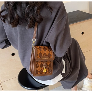 Detail shot of vintage brown diamond lattice mini crossbody bag with gold hardware buckle