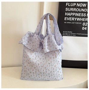 Détail du sac floral bleu clair avec volants plissés et texture gaufrée élégante