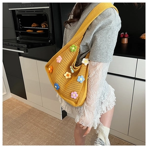 Detail of ginger yellow hand-knitted tote bag featuring colorful 3D crochet floral patterns