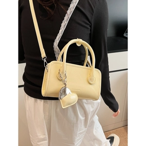Pale yellow PU leather bowling bag with heart charm and crossbody strap for women
