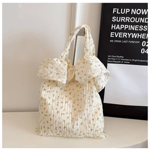 Détail du sac cabas floral blanc crème avec texture gaufrée et motifs de fleurs jaunes