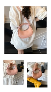 Detail of pink crescent handbag featuring vertical pleated texture and round handle