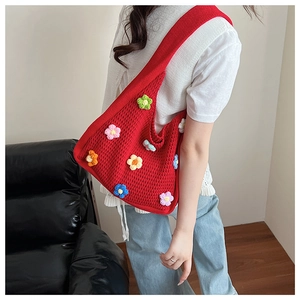 Detail of red handmade crochet shoulder bag featuring colorful 3D flower decorations