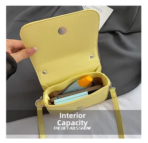 Detail shot of yellow leather crossbody bag showing internal capacity and pockets
