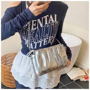Sac nuage plissé argenté avec bandoulière chaîne porté par un mannequin chez soi