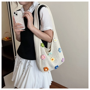 Detail of handmade crochet shoulder bag featuring colorful 3D floral embroidery