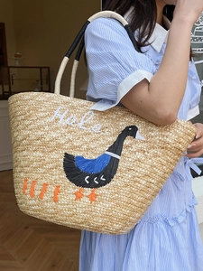 Handmade woven straw tote bag with embroidered goose pattern and Hola text for summer