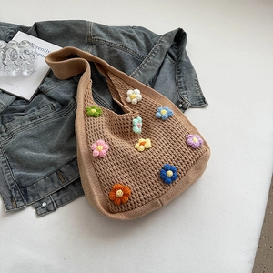 Detailed close-up of handmade crochet shoulder bag featuring colorful 3D flower pattern