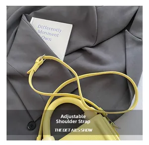 Detail view of yellow lychee texture handbag with adjustable metal buckle shoulder strap