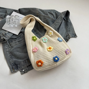 Detail of hand-woven cream crochet tote bag with colorful 3D knitted flower patterns