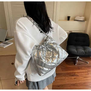 Vue détaillée du sac seau argenté matelassé avec clous en étoile et bandoulière chaîne