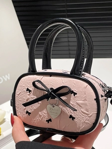 Mini sac à main plissé rose avec nœuds noirs et pendentif en forme de cœur argenté