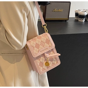 Detail of pink and white diamond quilted phone bag with gold hardware and logo