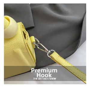 Detail showing high-quality silver swivel metal hook and yellow litchi grain leather strap